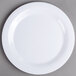 A Carlisle white melamine plate with a narrow rim on a gray surface.