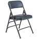 A black National Public Seating metal folding chair with a dark midnight blue cushion.