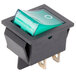 A green rocker switch with a white circle on the top.