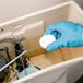 A person in blue gloves using 2000 Flushes Blue Plus Bleach toilet bowl cleaner.