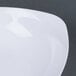 A close-up of a white Fineline plastic bowl.