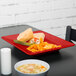 A red rectangular GET Red Sensation plate with food on it.