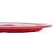 A red oval melamine platter on a table.