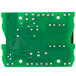 A green circuit board with silver metal and many small holes.