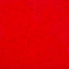 A red surface with black specks.