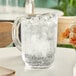 A Cambro clear plastic pitcher filled with ice water on a table.