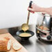 a loaf of bread on a cutting board next to a bowl of soup