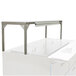 A white metal table with a Delfield stainless steel overshelf on top.