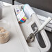 A gray Metro utility cart with a scoop and a container of powder on a tray.