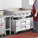 A woman cooking on a Cooking Performance Group countertop gas griddle.