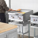 A man cooking on a Cooking Performance Group gas countertop griddle.