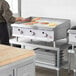 A man cooking food on a Cooking Performance Group gas countertop griddle in a professional kitchen.