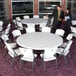 A white Lifetime round folding table with white folding chairs.