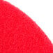 A close up of a red Scrubble by ACS buffing floor pad.