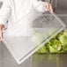 A person holding a clear Rubbermaid food storage box lid.