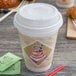 A Dart coffee cup with a white lid on a table.
