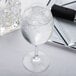 A Spiegelau red wine glass filled with ice water on a white background.