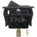 A black plastic Nemco rocker switch with a screw.