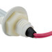 A white plastic plug with pink and red wires.