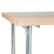 An Advance Tabco wood top work table with a galvanized metal base and undershelf.