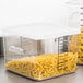 A Rubbermaid clear plastic container filled with pasta on a counter.