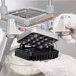 A hand holding a Nemco push block guide assembly over a metal plate.