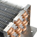 A close-up of an Avantco evaporator coil's copper tube and metal heat exchanger.