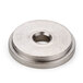 A silver round metal nut with a hole in the center.