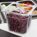 A Rubbermaid clear plastic food pan filled with food on a counter.