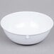 A white Carlisle Dallas Ware nappie bowl on a gray surface.