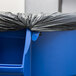 A blue Rubbermaid BRUTE trash can with a black plastic bag inside.