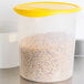 A translucent plastic Rubbermaid food storage container with a yellow lid filled with pasta.