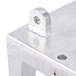 A metal bracket with holes and a screw on a table.