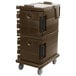 A dark brown plastic Cambro food pan carrier on wheels with black handles.