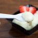 A Solo white plastic taster spoon holding white yogurt.