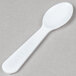 a white plastic spoon on a gray surface