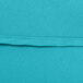 A close-up of a teal hemmed table cover.