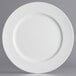 A close-up of a white Charge It by Jay plastic charger plate with a round edge.