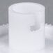 A white plastic gear with a hole in it.