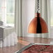 A Hanson Heat Lamps smoked copper retractable cord ceiling mount over a table of meat.