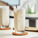 Two glasses of Big Train Vanilla Bean Frappes on a table.