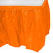 An orange plastic table skirt on a table.