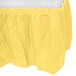 A yellow plastic table skirt with a white background.