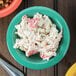 A bowl of crab salad in a rainforest green melamine bowl.