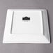 A white square porcelain plate with a black logo.