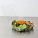 A salad in a Dart clear hinged plastic container with a lid.