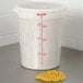 A white Cambro round polyethylene food storage container with a lid filled with noodles.