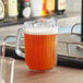 A clear plastic Choice beverage pitcher with brown liquid in it.
