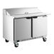 A stainless steel two-door refrigerated sandwich prep table with a raised cutting top and a 17-inch deep cutting board on wheels.