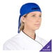 A woman wearing a royal blue Headsweats chef bandana.